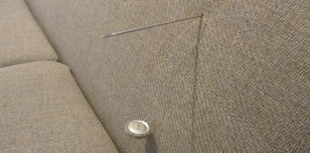 costura de botón sobre respaldo de tela para tapizar sillón