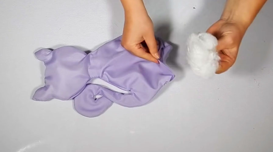 colocación de relleno en peluche de tela en forma de gatito