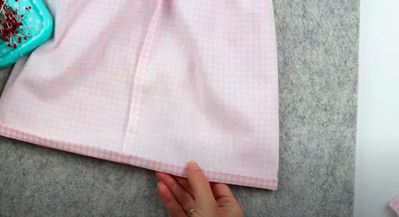 realización de costura de dobladillo inferior en tela para blusa de niña