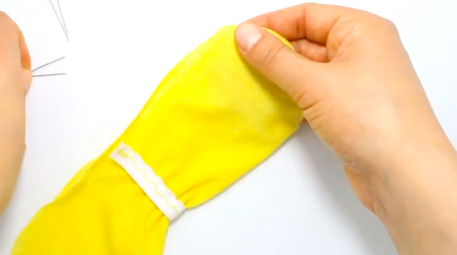 realización de doblez en piezas de tela para guantes de bebé