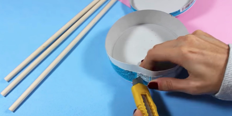 realización de agujero en caja de queso para tamborcito con tela para niños