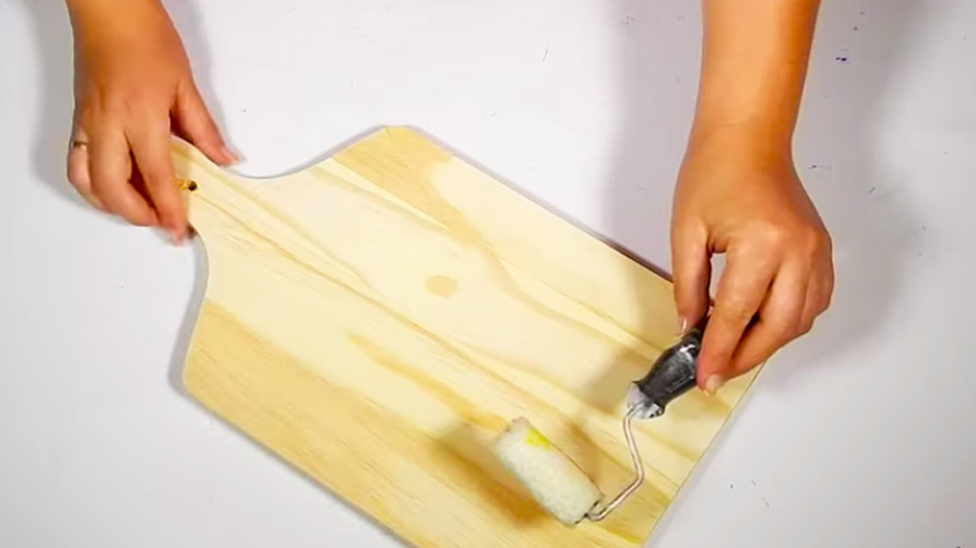 colocación de pegamento en tabla de madera para porta cucharas con tela